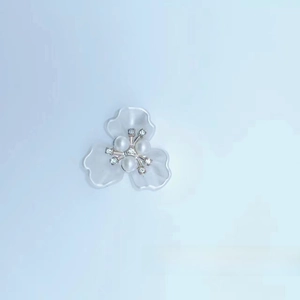 Close-up of three-petal resin flower charm with pearls and crystals for DIY crafts