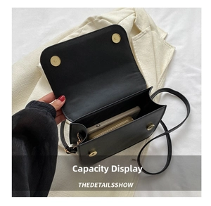 Detail view of the black crossbody bag interior showing phone and wallet storage space