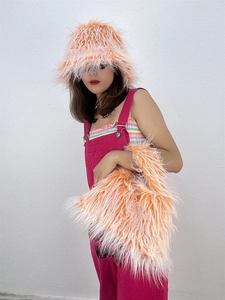 Detailed texture of orange faux sheepskin bucket hat and matching plush handbag set