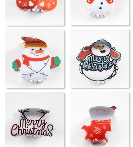 Detail of Christmas hair claws featuring snowman and snowflake designs on white background