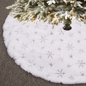 Close-up of white plush Christmas tree skirt with silver sequin snowflake embroidery detail