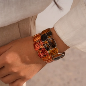 Close-up of geometric enamel bracelet with retro amber resin and hammered metal finish