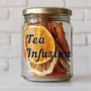 Detailed close-up of dried orange slices in a glass jar with gold lid for tea infusion