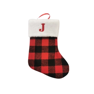 Detail of red and black plaid Christmas stocking with white faux fur trim and red letter J