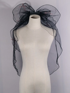 Detail of double-layer black tulle bridal veil with red stitching and hair comb attachment