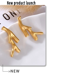 Macro shot of gold-plated tree branch earrings showing smooth PVD mirror finish detail