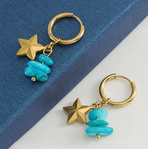 Detail of 18k gold star earrings featuring stacked natural turquoise stones on blue box