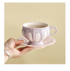 Close-up of vintage embossed ceramic coffee cup with intricate relief patterns and handle