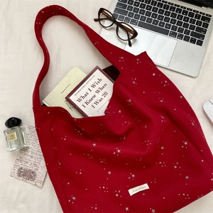 Dettaglio borsa tote in lana rossa con stelle argentate e interno capiente