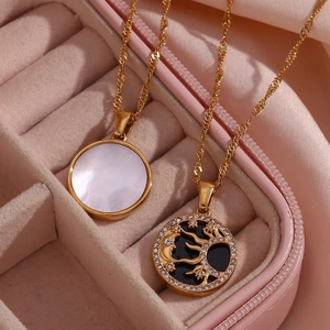 Detail of 18K gold-plated sun and moon pendants with mother of pearl in a pink jewelry box