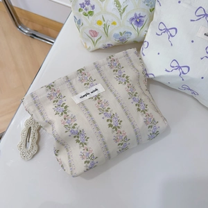 Vue détaillée de trousses à maquillage fleuries en tissu et pince à cheveux tricotée