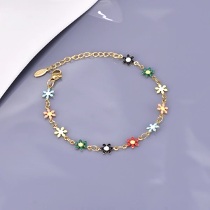 Détail d'un bracelet doré avec marguerites en émail coloré et breloque gravée S925