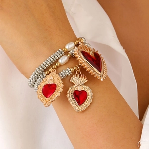 Retro-Boho-Perlenarmband-Set in Gold und Silber mit roten Herzanhängern am Handgelenk