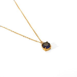 Detail view of a gold-plated stainless steel chain with a deep blue faceted gemstone
