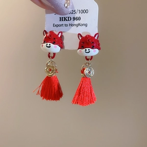 Detail of red enamel horse stud earrings with gold coin charms and silk tassels
