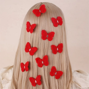 Detailed view of ten red felt bow hair clips arranged on a girl's blonde ponytail
