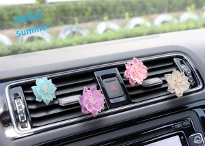 Detailed close-up of four colorful crystal lotus car air vent aromatherapy clips