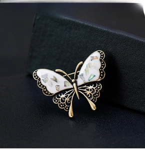 Macro detail of butterfly brooch with shell inlay and vintage gold finish