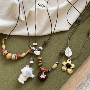 Détail de colliers bohèmes en perles avec pendentifs en forme de cœur et de fleurs