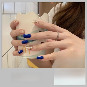 Detail of blue and champagne gold glitter nail wraps with solid color gradient pattern