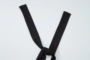 Detail of black ribbed fabric with knotted strap design for a backless summer dress