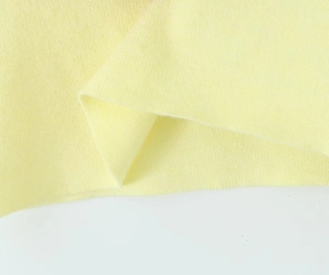 Vista macro detallada de la textura de tela de punto amarillo pálido y tejido suave