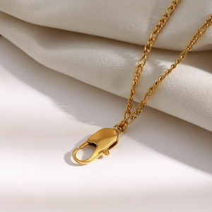 Vue macro d'un collier chaîne torsadée en acier inoxydable plaqué or avec fermoir mousqueton