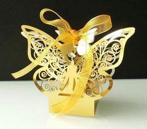 Macro detail of golden laser-cut butterfly gift box with elegant ribbon and pearlescent finish