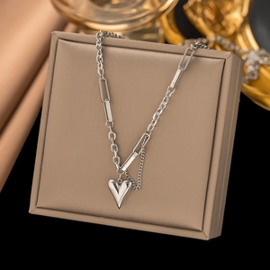 Collier avec pendentif cœur en acier argenté et chaîne à maillons sur boîte de luxe