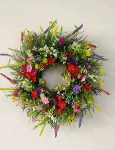Close-up of vibrant artificial flower wreath with mixed blooms and natural twig base