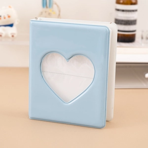 Close-up of a light blue photo album with a heart-shaped window and a silver chain