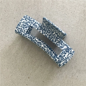 Detail of blue and white marble pattern on rectangular hair claw clip for elegant styling
