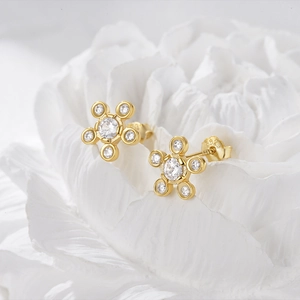 Macro detail of gold S925 silver flower earrings with zircon insets on petals