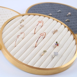 Round metal jewelry display trays with striped velvet inserts for rings and earrings