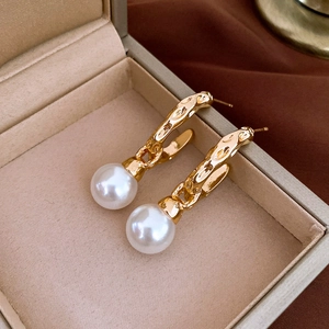 Macro detail of French vintage pearl earrings with gold base in a beige jewelry box