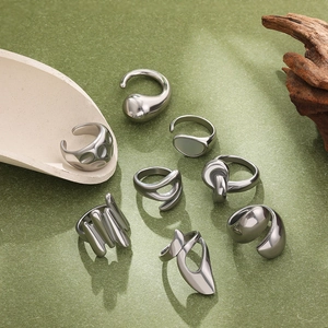 Artistic collection of eight irregular silver liquid metal knot rings in a still life display