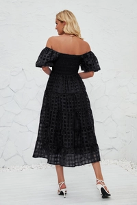 Detailed back view of a black puff sleeve tiered dress with textured plaid fabric