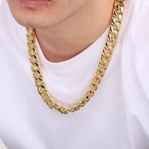 Close-up of a 15mm thick gold Cuban link chain necklace worn by a male model