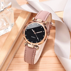 Detail view of starry sky dial watch with faceted crystal lens and pink leather strap