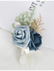 Detailed shot of handmade blue rose boutonniere with gold accents and silk ribbon