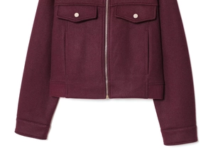 Dettaglio della giacca in lana bordeaux con zip in metallo e tasche con patta e bottoni