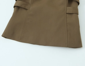 Detail of brown fabric with double stitching and decorative waist strap on a sleeveless top
