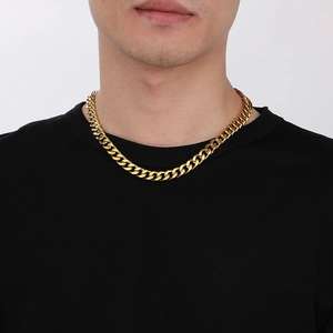 Male model wearing a thick golden cuban link chain necklace against a clean white background
