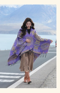Detail of purple ethnic pattern shawl with black tassels against a scenic mountain backdrop