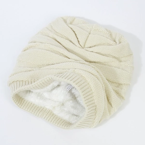 Cream knit beanie with thick fleece lining and warm ribbed texture for winter wear