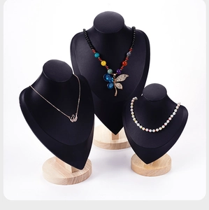 Three-piece black portrait necklace display stands with wooden bases in graduated heights