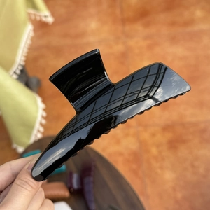 Detail view of large 13.5cm glossy black shark hair claw clip showing polished finish