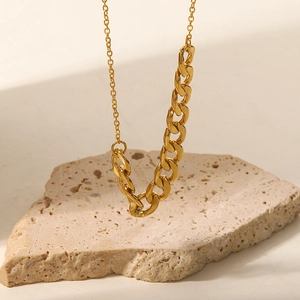 Vue détaillée du collier à chaîne gourmette dorée sur support en pierre naturelle chic