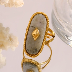 Macro view of vintage 18K gold plated oval grey stone ring with intricate beaded edge