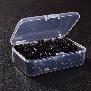 Macro shot of polished black mineral stones inside a transparent plastic storage box